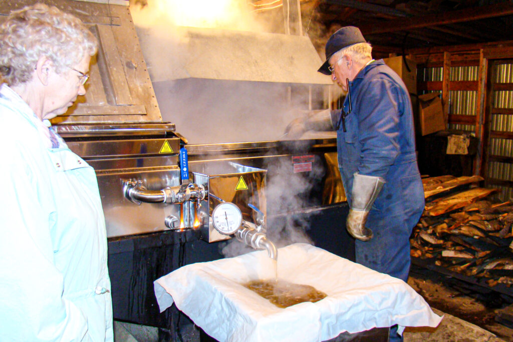 Thelma and Delmer making maple syrup